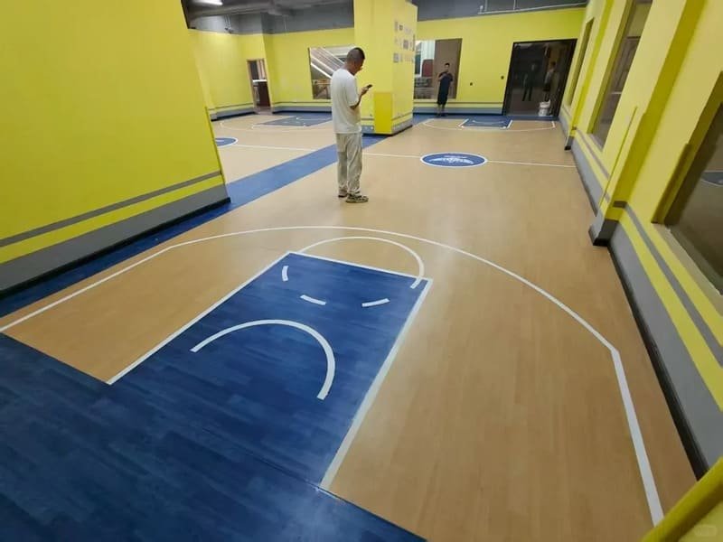 A maintenance worker cleaning high performance vinyl flooring with a machine